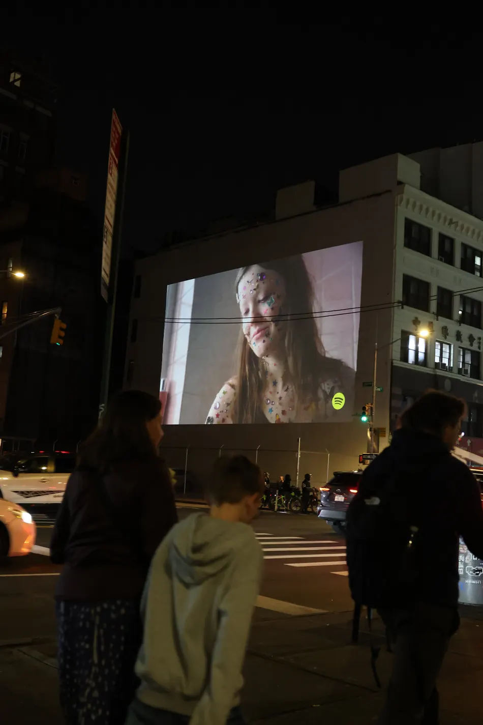 People recording a projection advertising campaign on phones